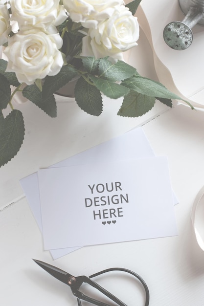 Blank white paper card with flower bouquet on wooden table