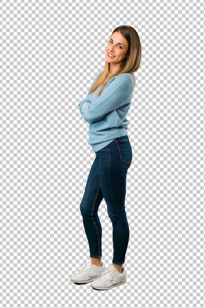 Blonde woman with blue shirt keeping the arms crossed in lateral position while smiling