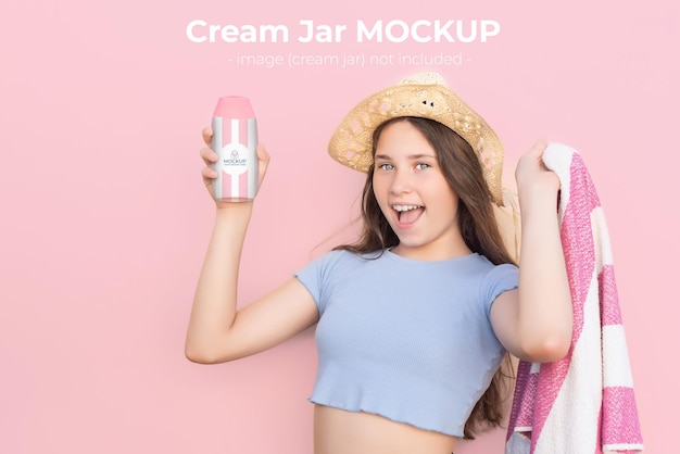 Blueeyed Caucasian girl mockup wearing a beach hat and towel showing a bottle of sunscreen block