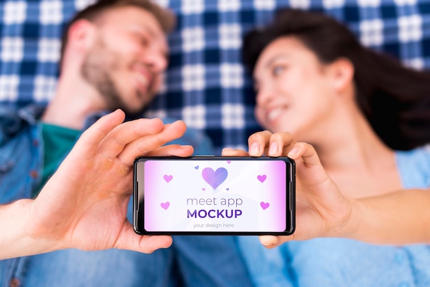 PSD blurred people holding meet app mock-up on mobile phone