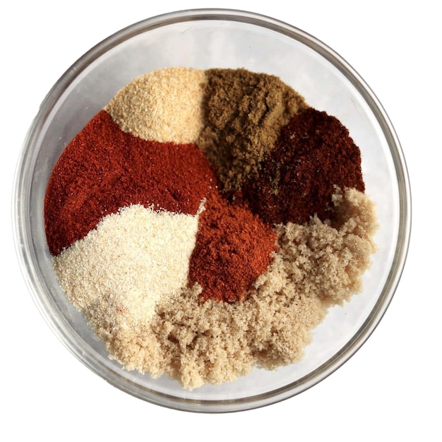 a bowl of different colored spices in a glass container