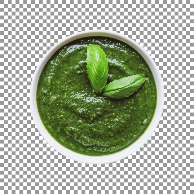 A bowl of green pesto with basil leaves on it