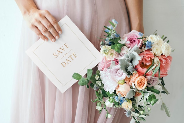 PSD bride holding a save the date card mockup with a bouquet of flowers