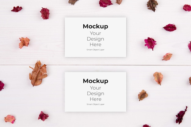 Business card mockup and flower dry on wooden table