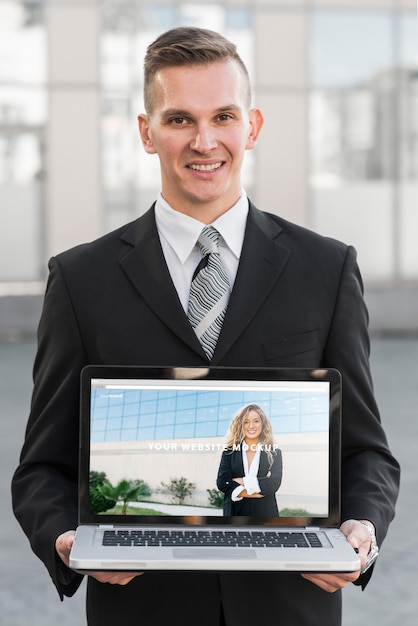 Businessman presenting laptop mockup