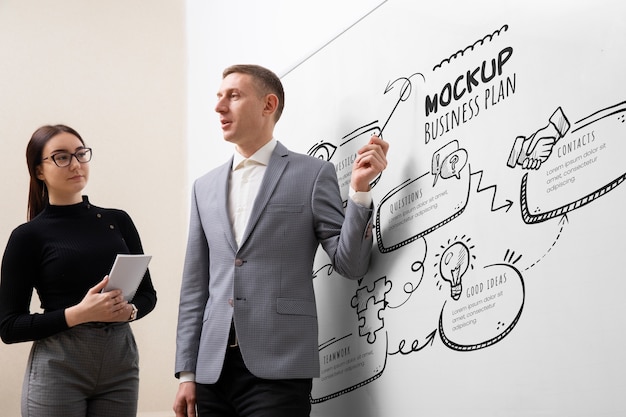 PSD businessperson presenting in a meeting on big white board mockup