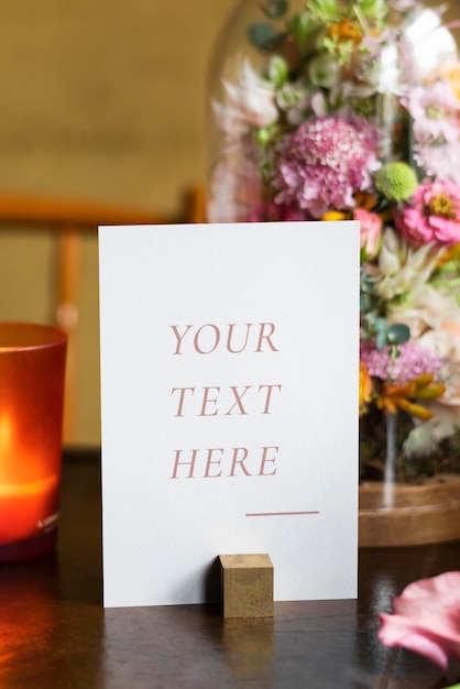 Card mockup by bouquet of flowers on a wooden table