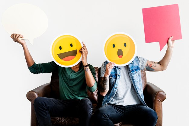 Cheerful people holding emoticon icon