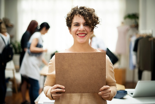 PSD a cheerful woman is showing a brown sign