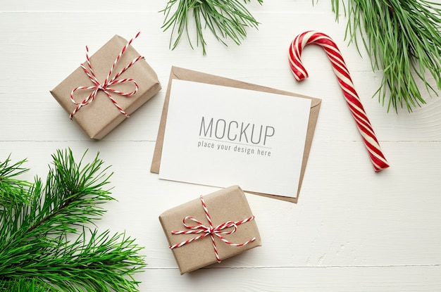 Christmas card mockup with gift boxes, candy cane and pine tree branches