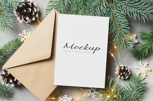 Christmas greeting card mockup with envelope and fir tree with cones and garlands