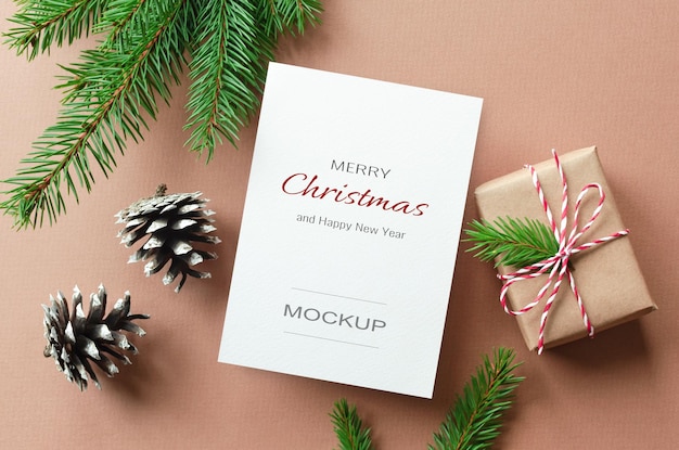 Christmas greeting card mockup with gift box and fir tree branches with cones