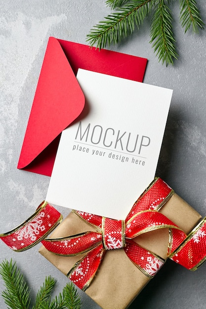 PSD christmas greeting or invitation card mockup with envelope, gift box and fir tree branches