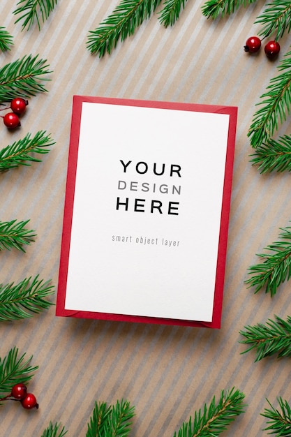 Christmas greeting or invitation card mockup with red envelope and fir tree branches