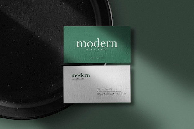 Clean minimal business card mockup on black plate with shadow 