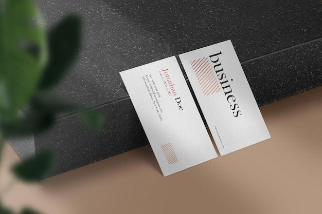 Clean minimal business card mockup on black stone plate side 