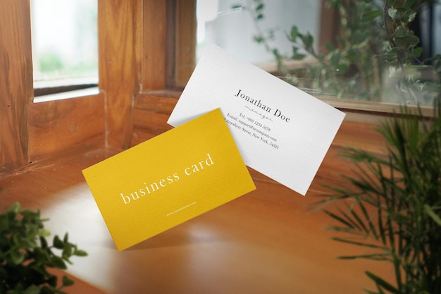 Clean minimal business card mockup on cafe background with plants