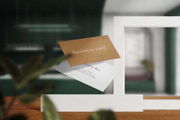 Clean minimal business card mockup floating on white block with leaves background. PSD file.