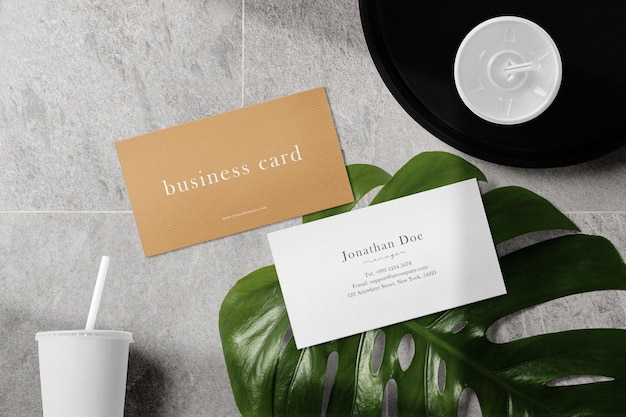 Clean minimal business card mockup on tile background with leaf tray and 2 cups