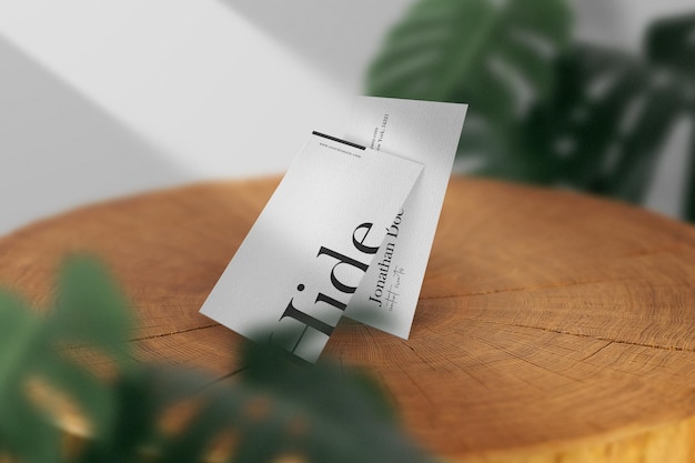 Clean minimal business card mockup on timber with leaves background. PSD file.