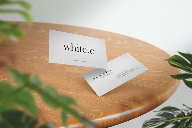 Clean minimal business card mockup on top table with leaves