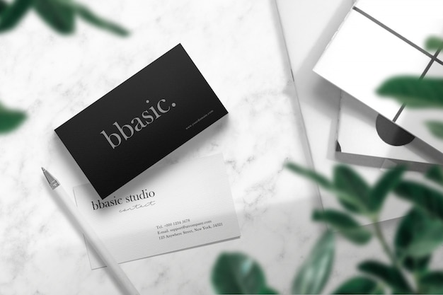 Clean minimal business card mockup on white marble with books and pen