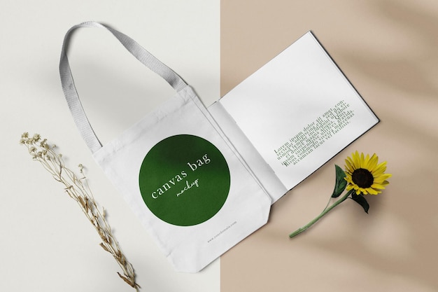 Clean minimal canvas bag mockup on 2 tone background with branches book and sunflower