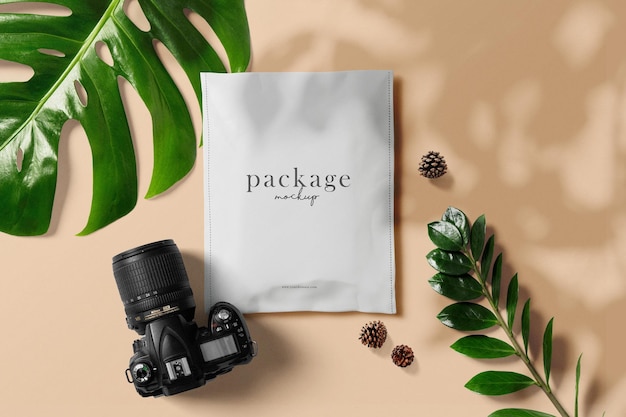 Clean minimal packaging mockup on minimal background with leaves cones and camera