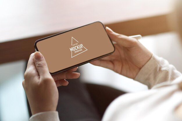 Close up of blank horizontal smartphone screen, female holding smartphone with blank copy space