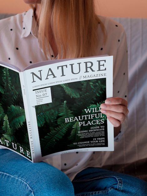 Close-up casual dressed woman holding a mock up magazine