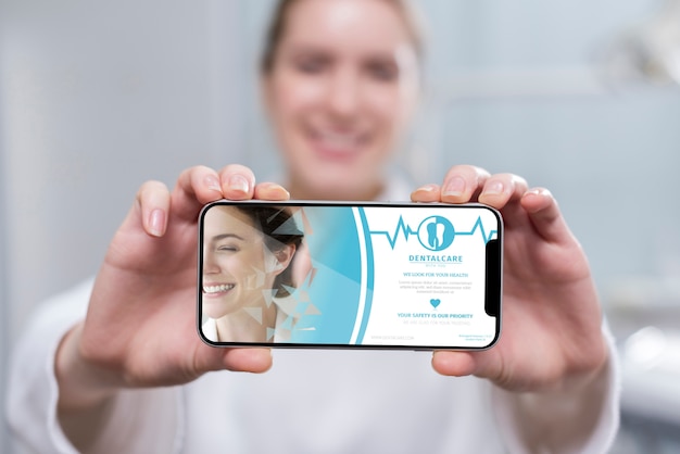 Close-up dentist holding a smartphone