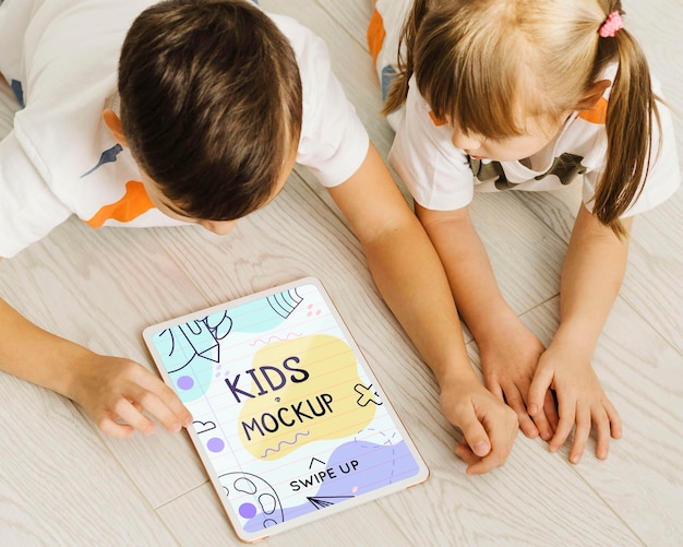 Close up kids on floor with tablet