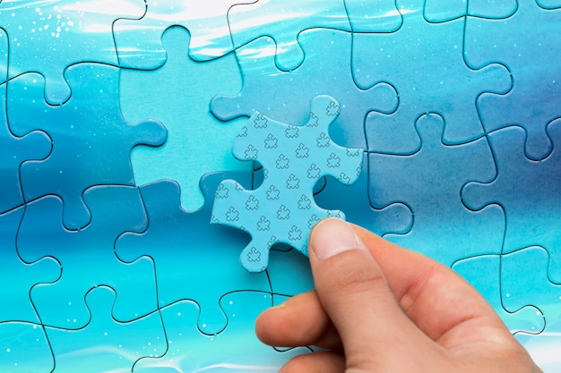 Close-up man holding a piece of puzzle