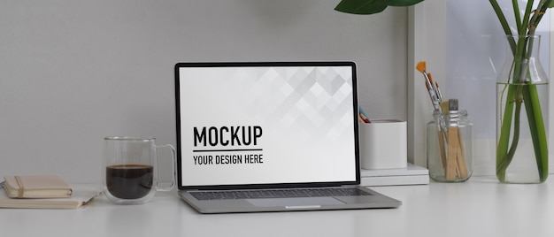 Close up view of mock up laptop on white table with stationery and decorations in home office room