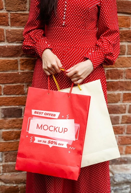 Close-up woman holding shopping bags outdoors