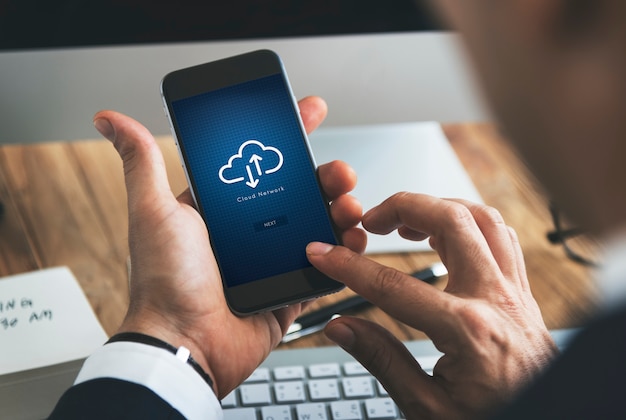 Closeup of businessman using smartphone with cloud computing symbol