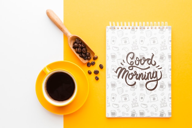 Coffee cup next to a notebook mock-up