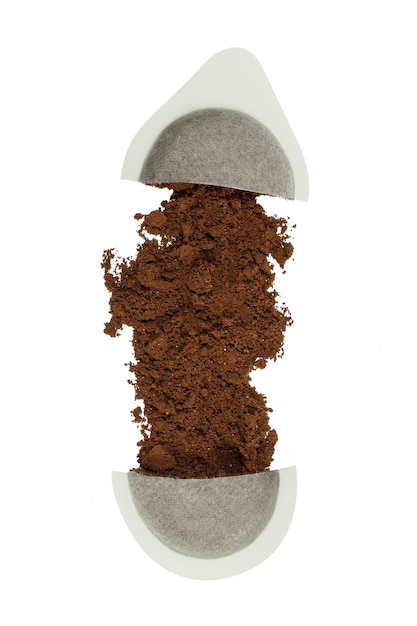 coffee in a cut capsule scattered on an empty background