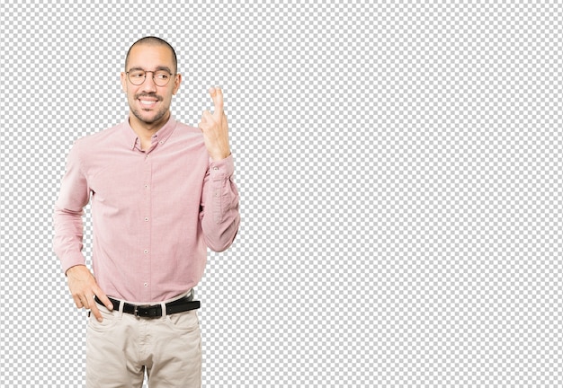 Concerned young man doing a crossed fingers gesture