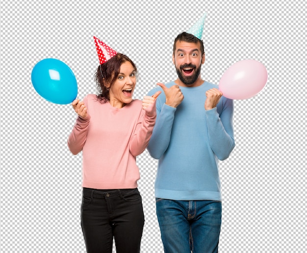 PSD couple with balloons and birthday hats giving a thumbs up gesture