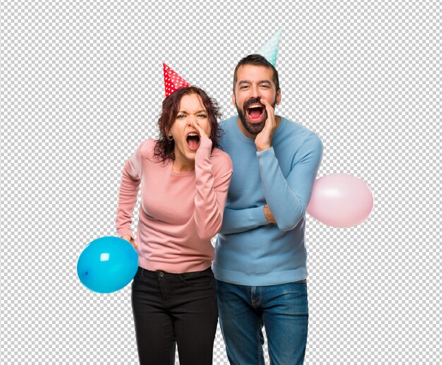 PSD couple with balloons and birthday hats shouting with mouth wide open and announcing something