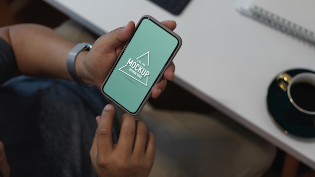 Cropped shot of male office worker using mock up smartphone