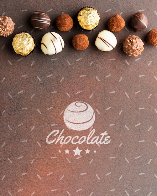 Delicious chocolate candies with brown background mock-up