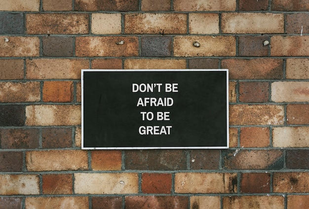 PSD don' be afraid to be great board mockup on a brick wall