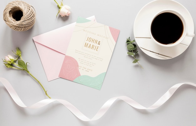 Fat lay of wedding card with ribbon and coffee