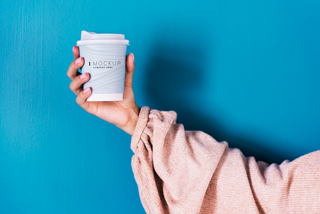 PSD female hand holding a coffee cup mockup