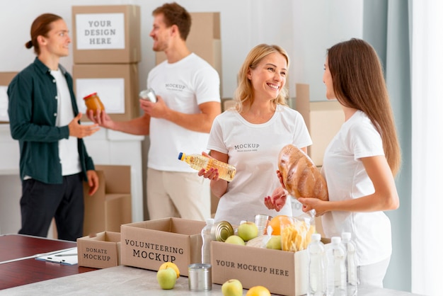 Female volunteers preparing donations boxes and man donating provisions