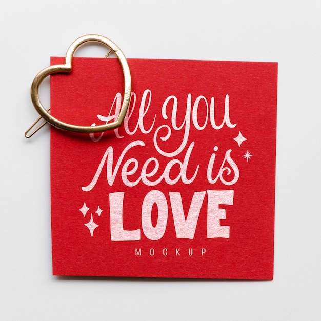 Flat lay of card with heart-shaped golden pin