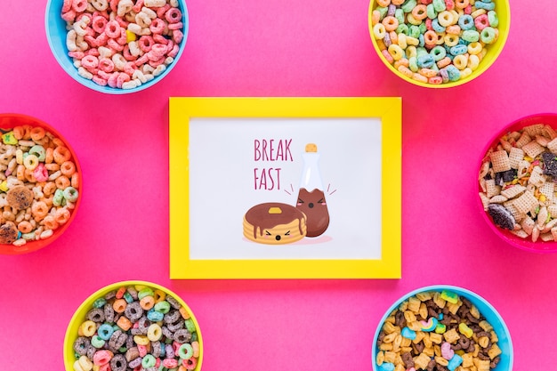 Flat lay of cereal bowls and frame with pink background