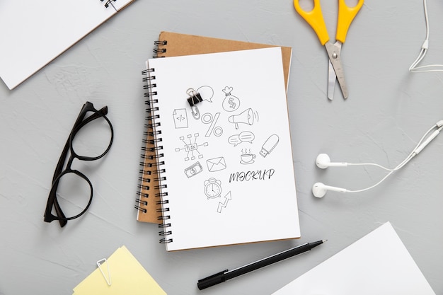 Flat lay of desk surface with earphones and notebooks